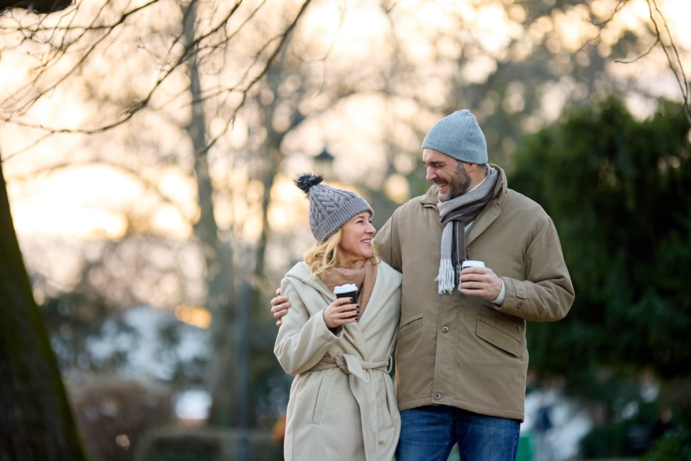 A couple walking with coffee outside during a winter couples getaway to our Newport RI Bed and Breakfast