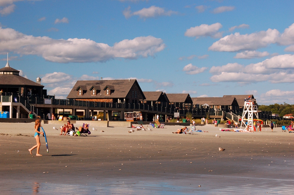 People enjoying the afternoon with buildings in the background at Easton's Beach, one of the best beaches in Newport, RI